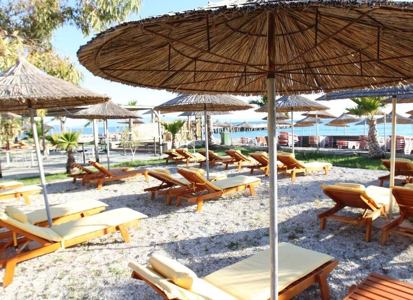 Bunec Beach Resort in Lukovë with sun loungers and straw umbrellas on a pebble beach