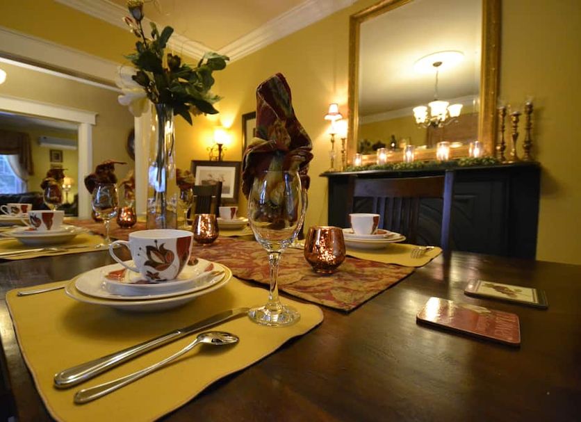 Briarwood Bed & Breakfast in Elmsdale dining room with set table, candles, mirror and fireplace mantel