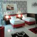 Cityhotel Ahlen Garni room with two twin beds, desk, chair and patterned accent wall in Ahlen