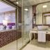 Tui Magic Life Jacaranda in Side bathroom with glass shower, vanity sink, and bedroom view