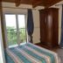 B&b Villa Chianalea, Scilla: guest room with balcony doors, wood wardrobe, and sea-view greenery