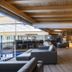 Schlosshotel Lacknerhof in Flachau lounge with modern seating, wood سقiling, and indoor pool view
