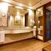 Pestana São Paulo bathroom with double vanity, large mirror, wood floor and glass shower