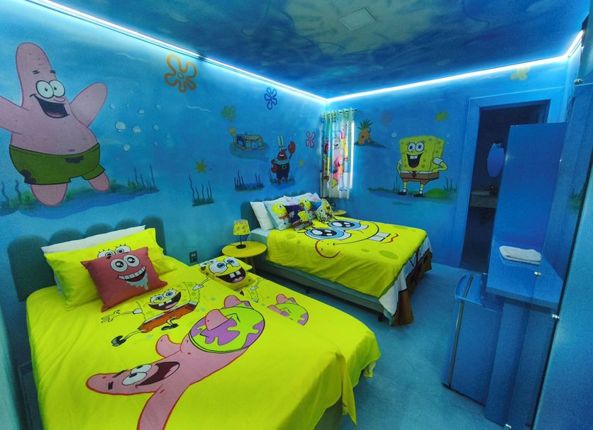 Pousada Caminho Dos Sonhos room in Penha with SpongeBob-themed beds and blue mural walls
