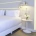 NH Monterrey La Fe guest room with white bed, bench, nightstands and modern lamps in Monterrey