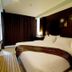 Ideal Hotel Pratunam Bangkok guest room with king bed, wall-mounted TV and dark curtains