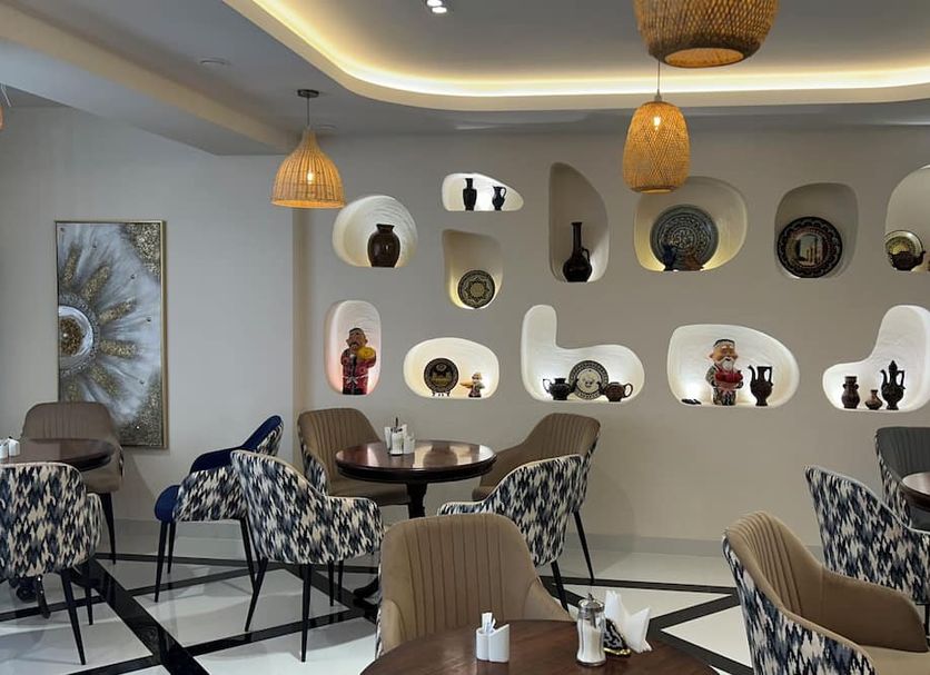 Karim Parkside Hotel Samarkand lounge with patterned chairs, round tables, and sculptural wall niches