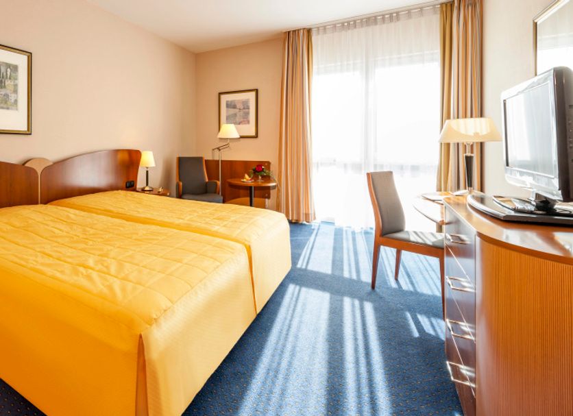 Apart-Hotel Halle in Halle guest room with double bed, desk, TV and bright window
