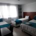 Hotel Casa Lamay Bogotá guest room with three beds, desk, and bright window