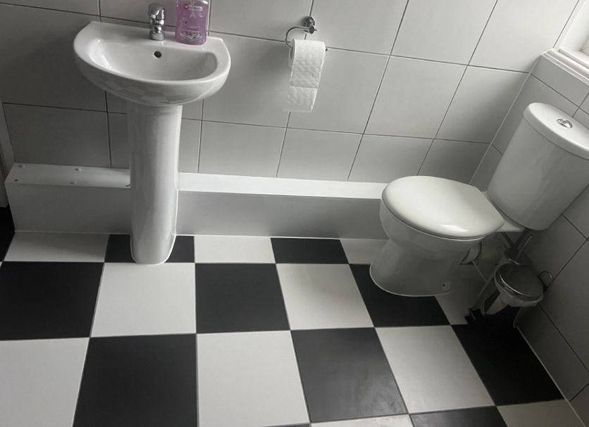 The Station Hotel, Norwich bathroom with pedestal sink, toilet and black-and-white checkered floor