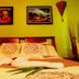 Arte Natura Boutique Hotel, La Fortuna: colorful guest room with made bed and framed wall art