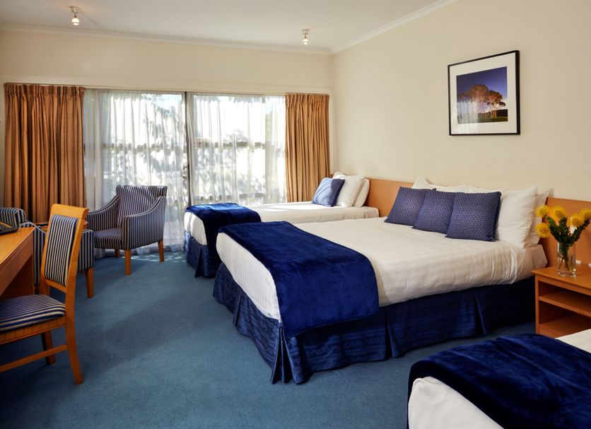 Saxton Lodge Nelson hotel room with two beds, blue carpet, seating area and window view