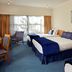 Saxton Lodge Nelson hotel room with two beds, blue carpet, seating area and window view