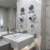 Hotel Bulgaria in Burgas bathroom with marble walls, vessel sink, wall-mounted hair dryers and toiletries