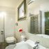 Albaruja Hotel in Costa Rei bathroom with glass shower, wall-mounted toilet and sink vanity