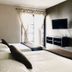 Ocean Breeze Santo Domingo guest room with two beds, wall-mounted TV and sheer-curtained window