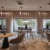 AC Hotels by Marriott Berlin Humboldthain Park lounge with tables, chairs and garden-view windows