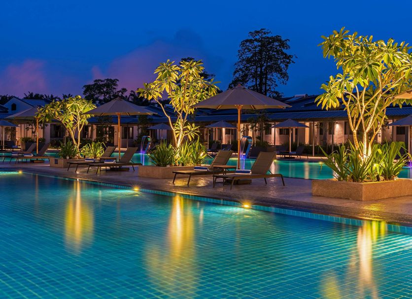 Ibis Styles Sepang Klia poolside with lit palm trees, lounge chairs and evening resort ambiance in Sepang