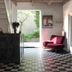 De Utrechtsche Dom lobby with checkered tile floor, staircase, and magenta lounge chair in Gouda