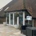Winchelsea Lodge in Winchelsea with a brick entrance, glass doors, and patio seating outside