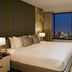 Somerset Rama 9 Bangkok bedroom with city skyline view through large window in Bangkok