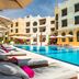 Juweira Boutique Hotel Salalah adults-only poolside loungers beside outdoor swimming pool and white hotel facade