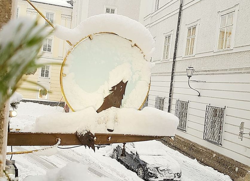 Hotel Wolf Salzburg snowy courtyard with circular sculpture and white building facades