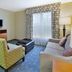 Homewood Suites by Hilton Philadelphia/Mt. Laurel room with sofa, armchair, TV and window view