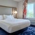 Fairfield Inn & Suites by Marriott Burlington guest room with king bed, bedside lamps, and window view