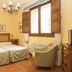 Vettonia in Ávila guest room with twin beds, window shutters, armchair, and TV