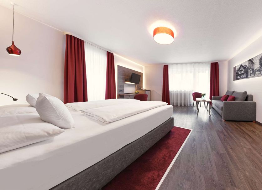 Top Countryline Hotel Ritter Badenweiler guest room with bed, seating area and large windows