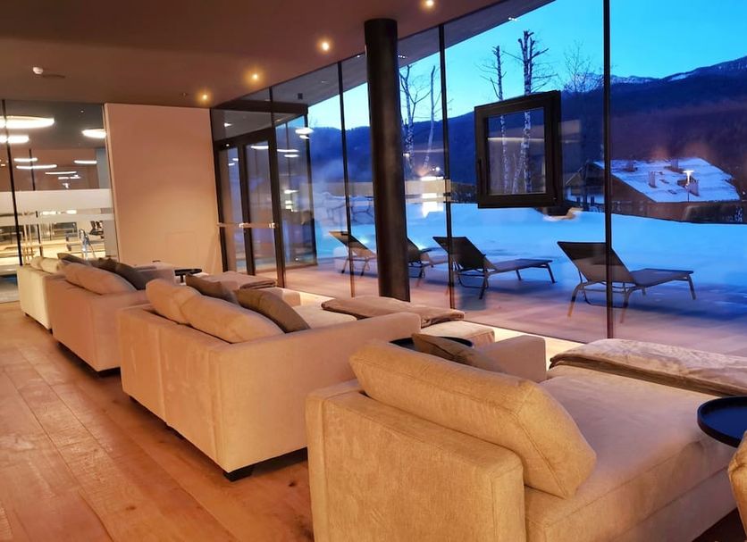 Parkhotel Ladinia in San Vito Di Cadore lounge with mountain and snow views through floor-to-ceiling windows