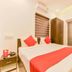 Hotel F Square in Kochi bedroom with double bed, red runner, nightstand, wardrobe and window blinds