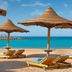Hilton Hurghada Plaza in Hurghada: beach loungers under straw umbrellas facing turquoise sea