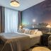 Original Sokos Hotel Kaarle, Kokkola room with cityscape wall mural, bed, and armchair