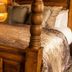 The Peel Aldergate, Tamworth: wooden four-poster bed with patterned pillows, bedside lamp and warm lighting