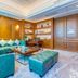 Hulunbeier Hotel in Hulunbuir lounge with teal sofas, ottoman, wood paneling, and built-in shelves