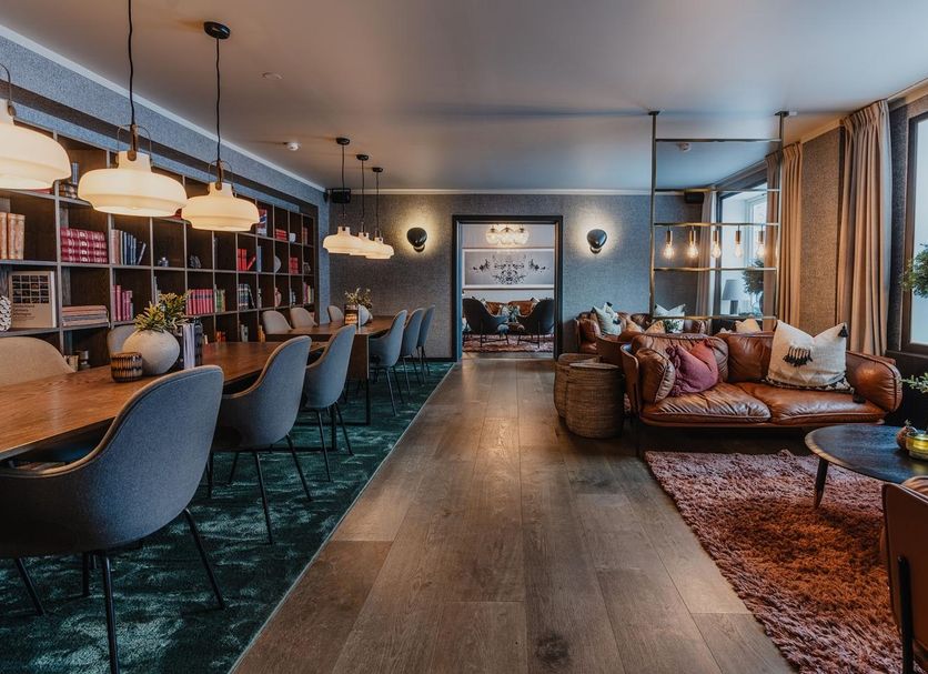 Funken Lodge Longyearbyen lounge with leather sofa, dining tables, and large window