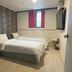 Hotel Atti Incheon guest room with two beds, wall-mounted TV, mini fridge and window