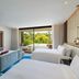 W Punta Cana, All-Inclusive room with twin beds, TV wall, sofa, and sliding doors to lush garden view in Uvero Alto