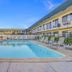 Motel 6 King City Ca in King City with outdoor pool and lounge chairs beside the motel building