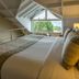 Los Ponchos Hotel in El Calafate bedroom with vaulted ceiling, loft railing, and large window view