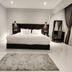 Helio Cairo Hotel room with a bed, gray rug, wall art, and floor-to-ceiling curtains in Cairo