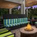 Home2 Suites by Hilton Lake City outdoor lounge with fire pit, striped seating and garden views