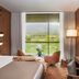 Jiva Hill Resort - Genève guest room with large window, lake and mountain views, desk and seating area