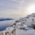 Santorini Mansion at Imerovigli with cliffside white suites overlooking the sea at sunset