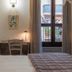 Hotel Il Tiglio in Castel di Sangro guest room with bed, desk, wall art and balcony door