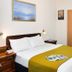 Sun City Hotel in Tel Aviv guest room with double bed, bedside lamps, wall art, TV, and curtains