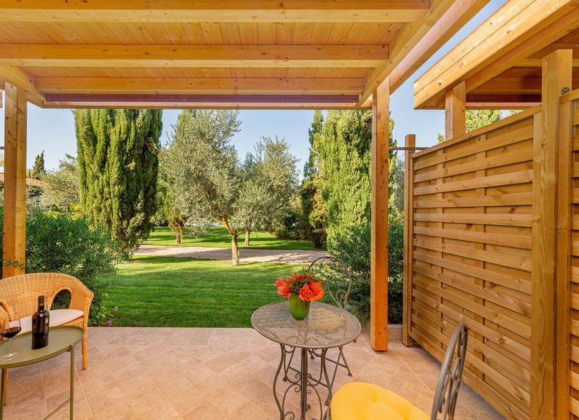 Wine Resort Ledà D'Ittiri in Alghero with a covered patio overlooking a garden and trees