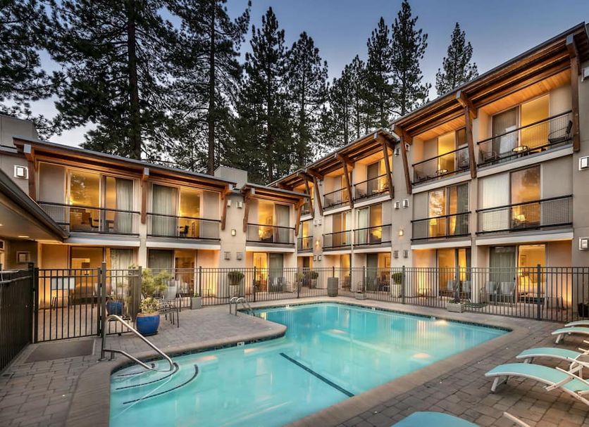 Firelite Lodge in Tahoe Vista with outdoor pool, balcony rooms, and pine trees at dusk